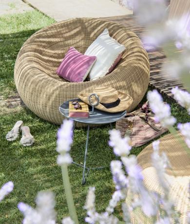 Summer garden with cozy chair, colorful pillows, and scent of lavender.