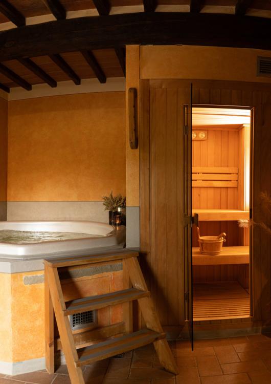 Spa con vasca idromassaggio e sauna in ambiente rustico e accogliente.