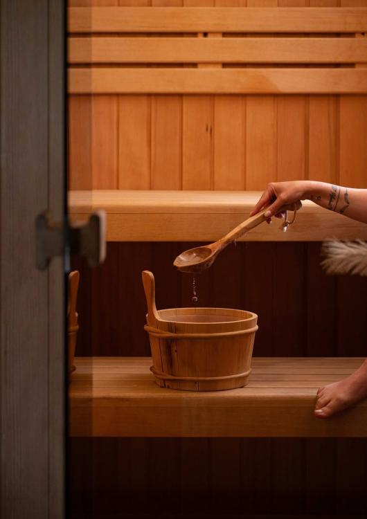 Interno di una sauna con secchio di legno e mestolo per l'acqua.