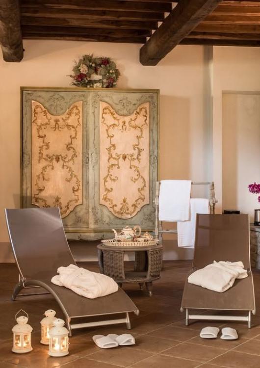 Sala relax con lettini, lanterne, fiori e arredi eleganti.