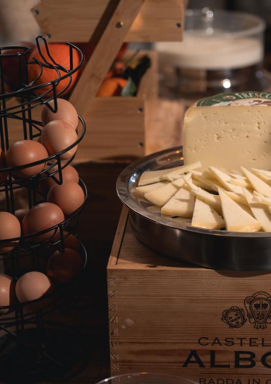 Formaggio a fette su un piatto, accanto a un portauova a spirale.