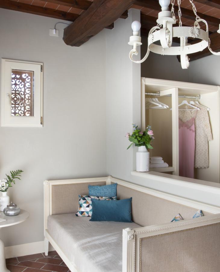 Elegant room with sofa, lamp, and flowers, creating a cozy and relaxing atmosphere.