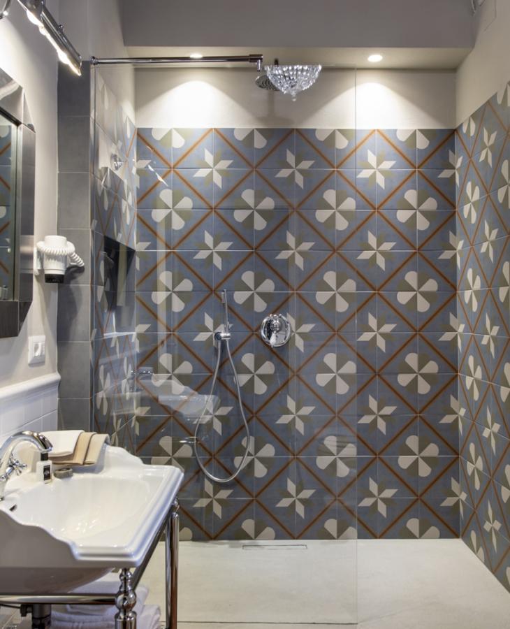 Elegant bathroom with modern shower and colorful geometric tiles.